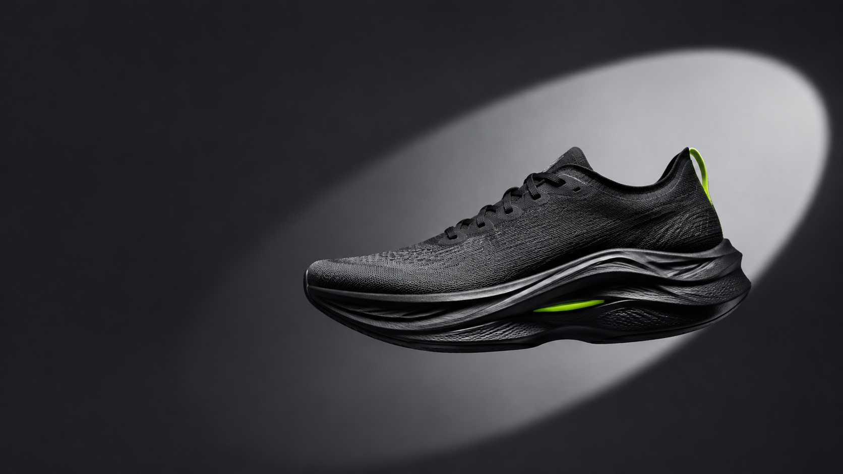 Black performance running shoe suspended in a studio